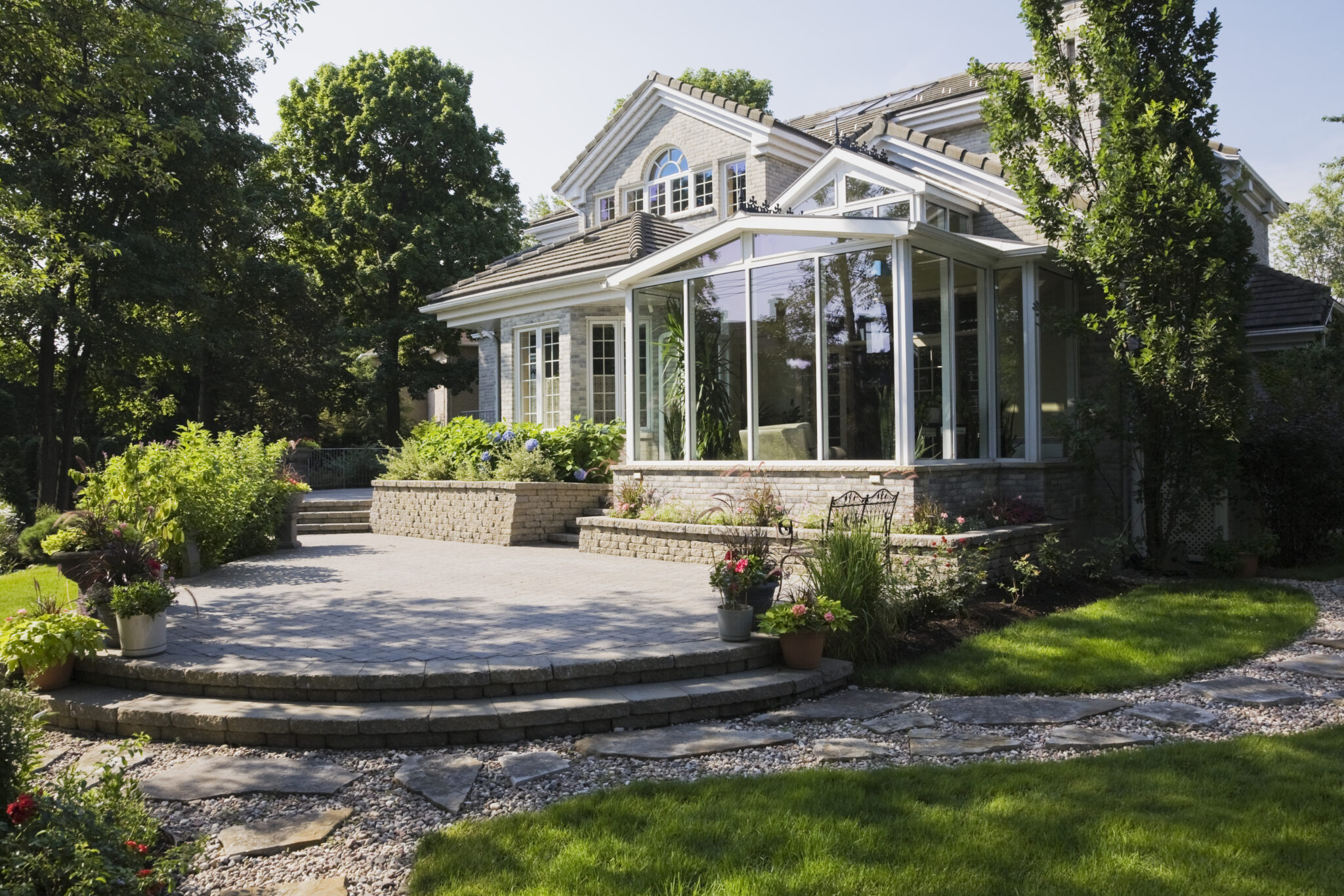 Brick and stone cottage-style home with a sunroom and patio